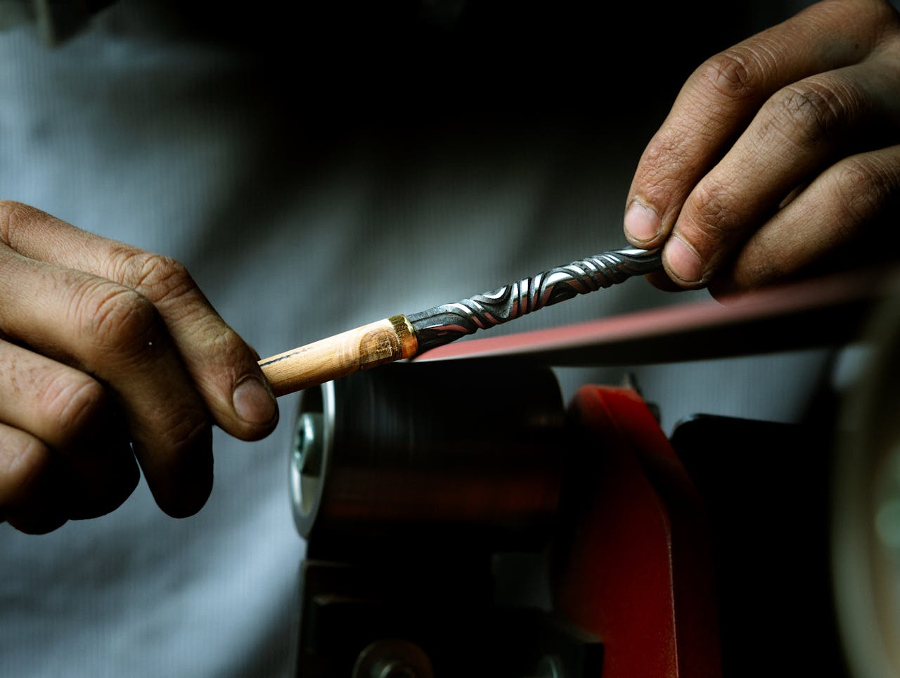 Close-up of artisan hands sharpening a tool in a Gradignan workshop, Nouvelle-Aquitaine.
